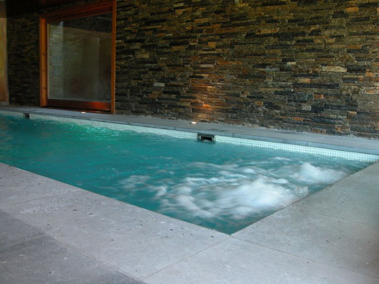 Piscina interior con muro de piedra, proyecto de MA&MA POOL